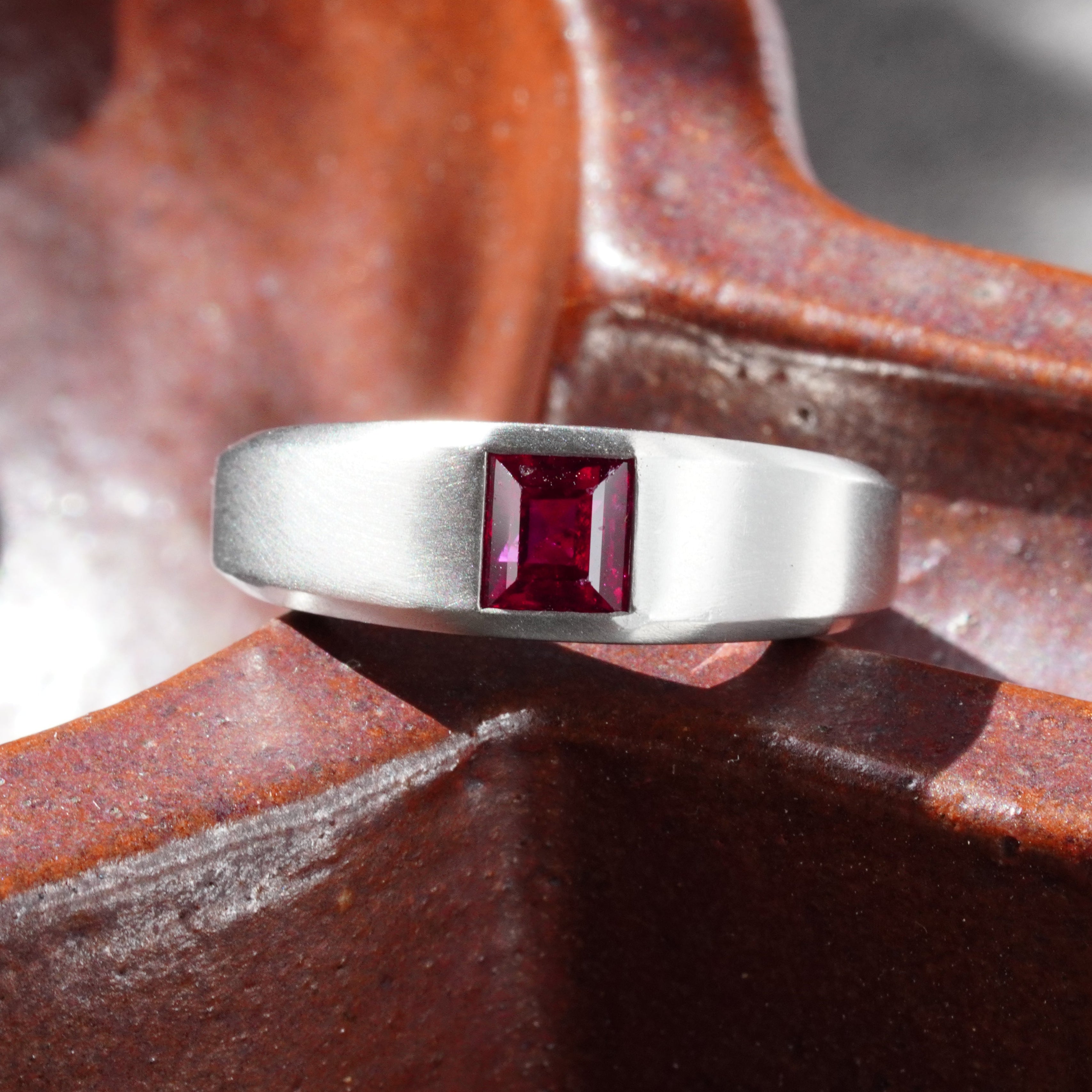 A 1.15-carat step-cut Burmese ruby ring, featuring a clean red gemstone set in a platinum flush setting, presented by Jogani.