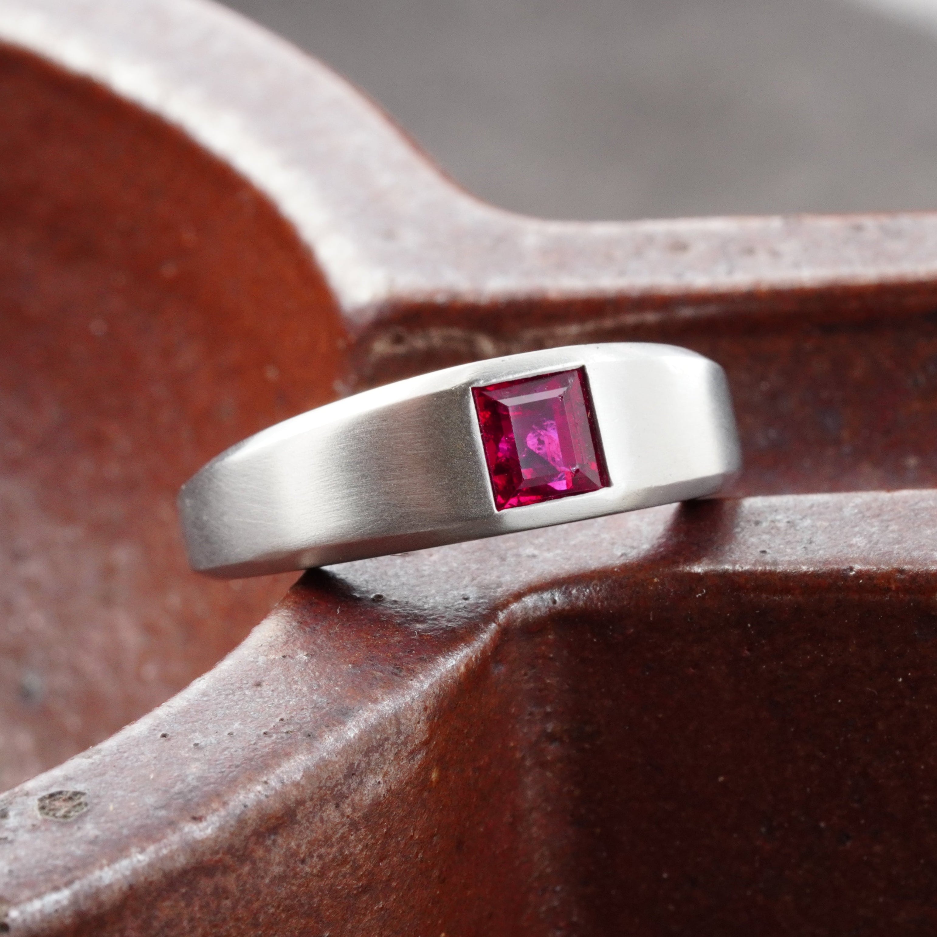 A 1.15-carat step-cut Burmese ruby ring, featuring a clean red gemstone set in a platinum flush setting, presented by Jogani.