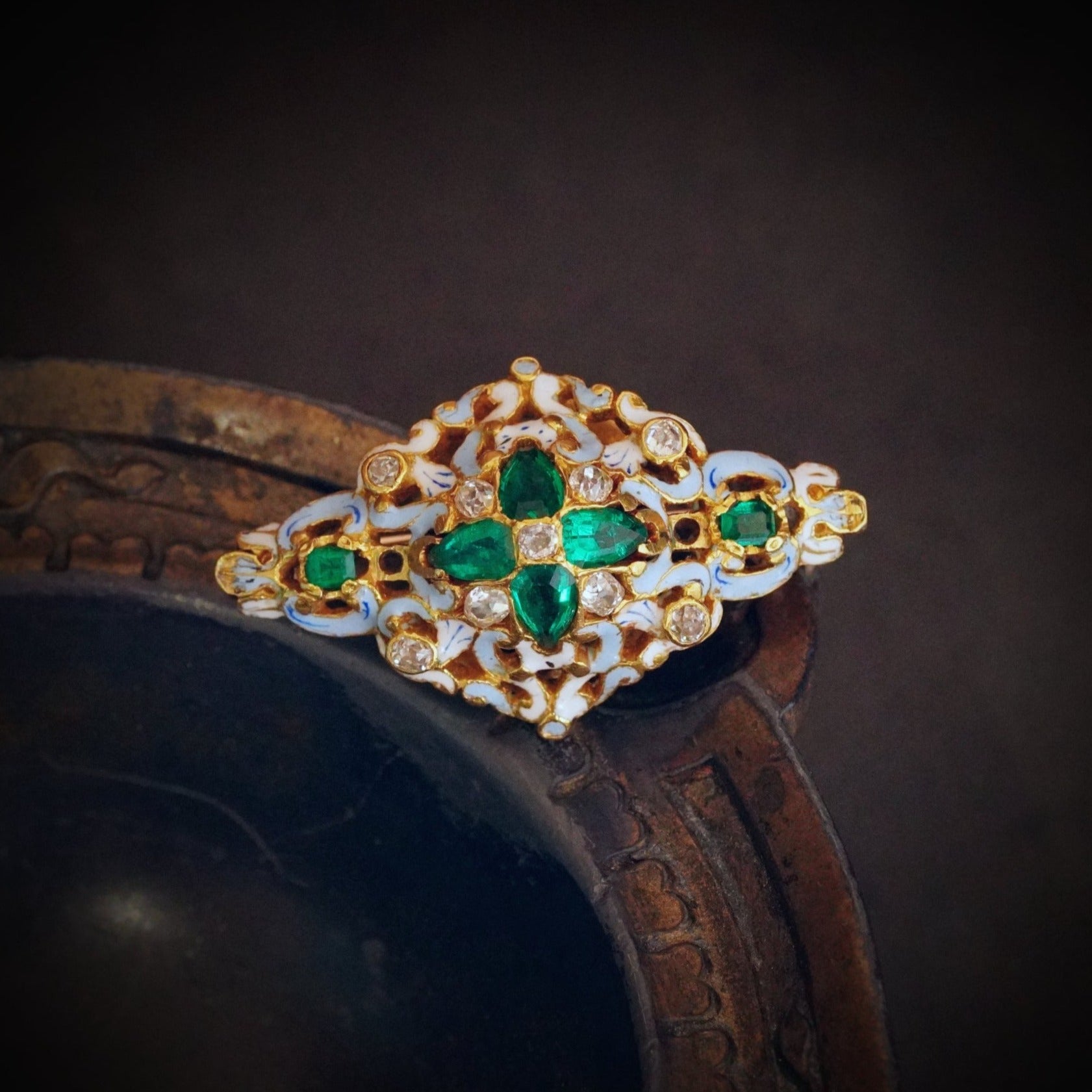 Victorian-era Colombian emerald and diamond brooch, curated by Jogani, featuring deep green emeralds set in an exquisite gold and enamel framework.