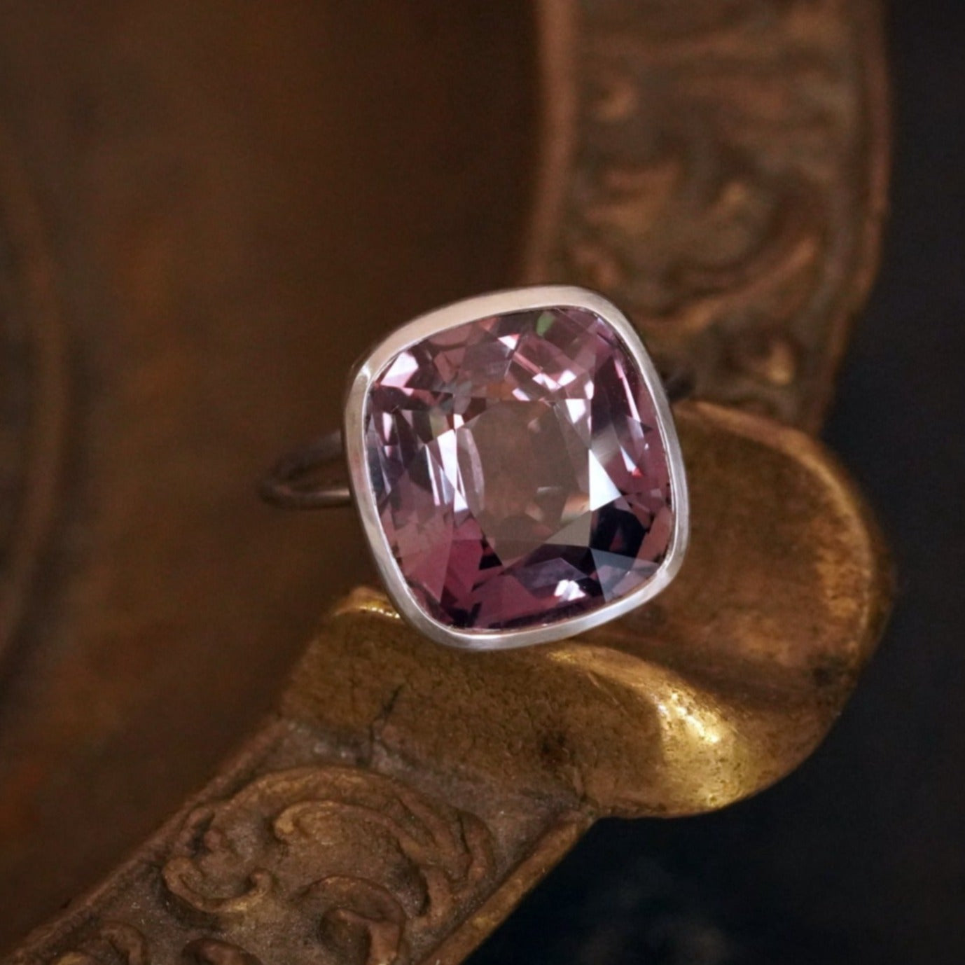 A mesmerizing 10.11 ct Cushion Cut Ceylon Alexandrite ring, crafted in platinum by Jogani. Its color shifts between brownish green and reddish-purple, making it a rare collector’s treasure.