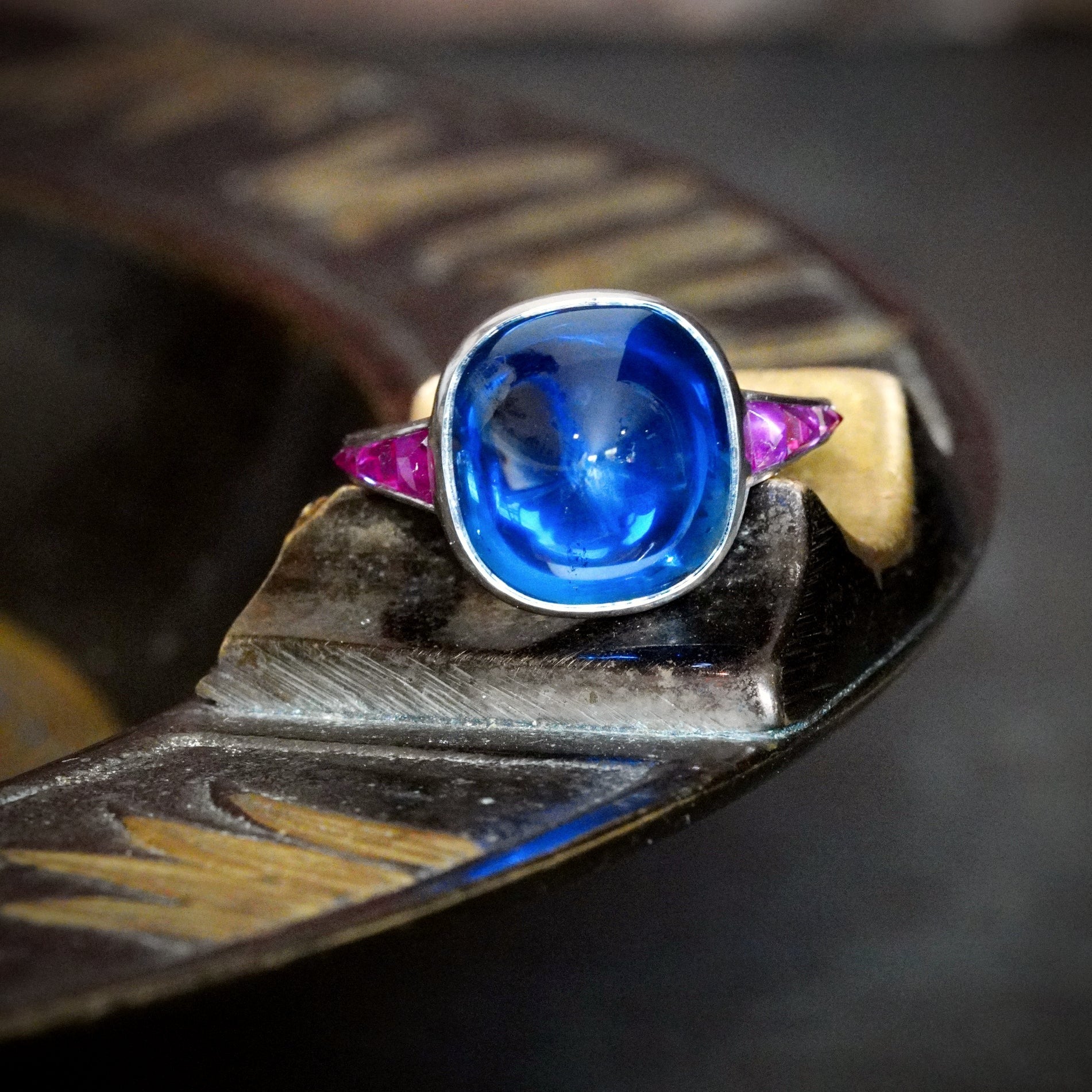 Jogani presents an extraordinary 10.99 ct no-heat Burma sapphire ring, featuring a rich blue sugarloaf-cut gem surrounded by rubies in a platinum setting.