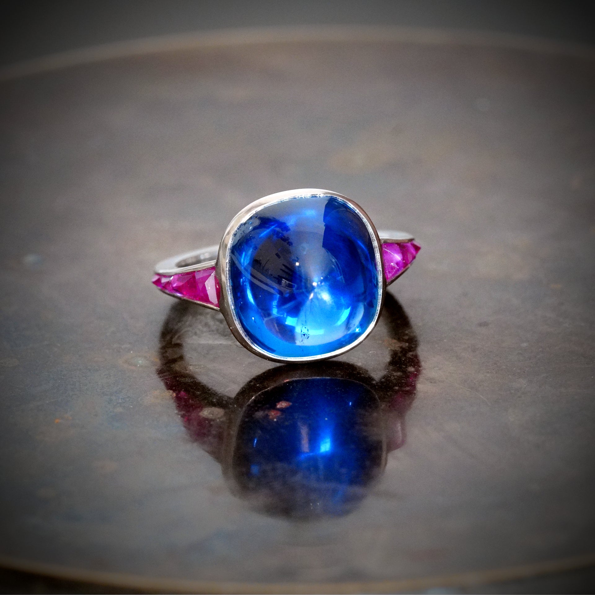 For serious collectors—this 10.99 ct sugarloaf-cut Burma sapphire ring, accented with rubies, is a rare find. Crafted with excellence by Jogani.