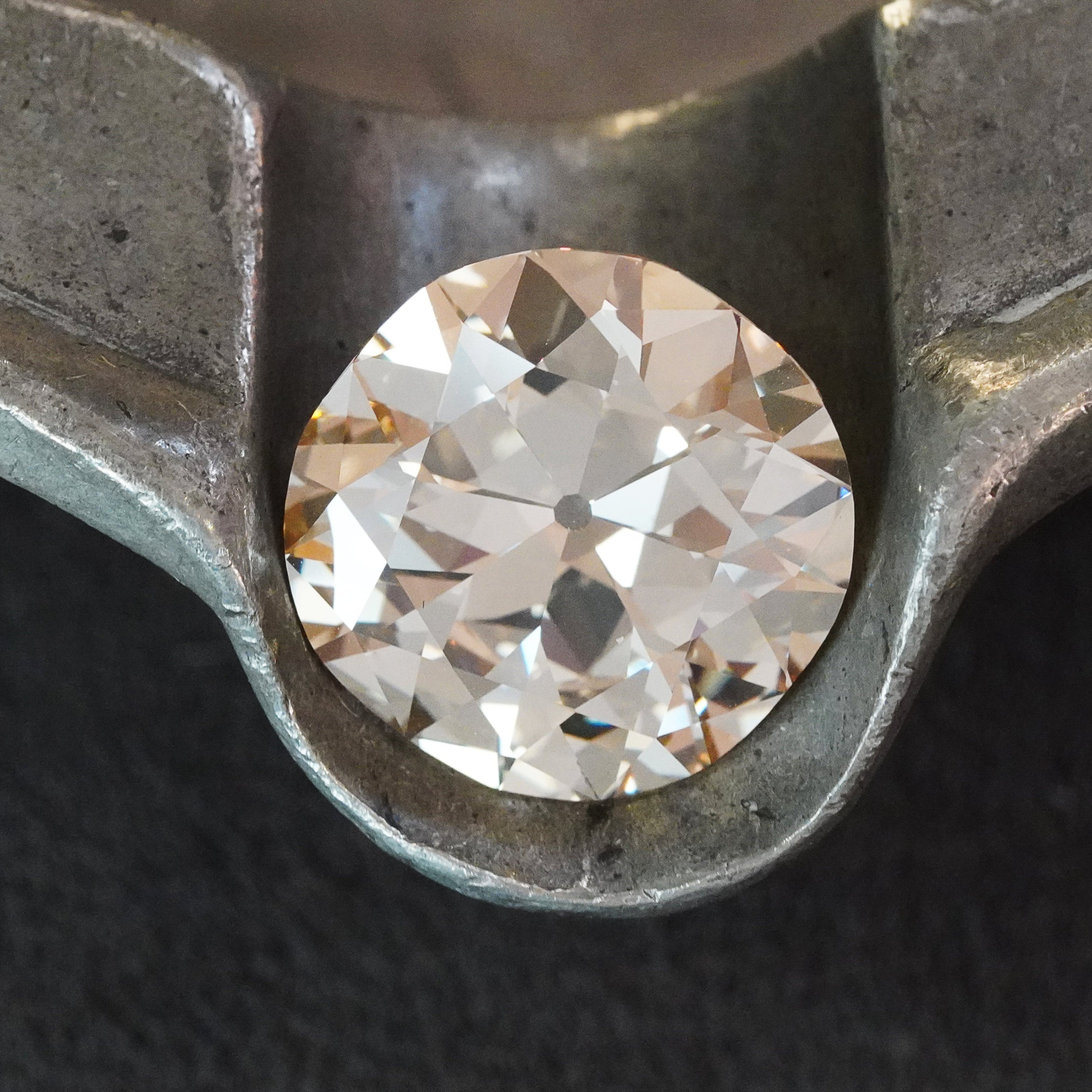 Close-up of a 12.21 carat cushion cut diamond, showcasing its rich color, clarity, and expert faceting. A luxurious gemstone with a timeless appeal.