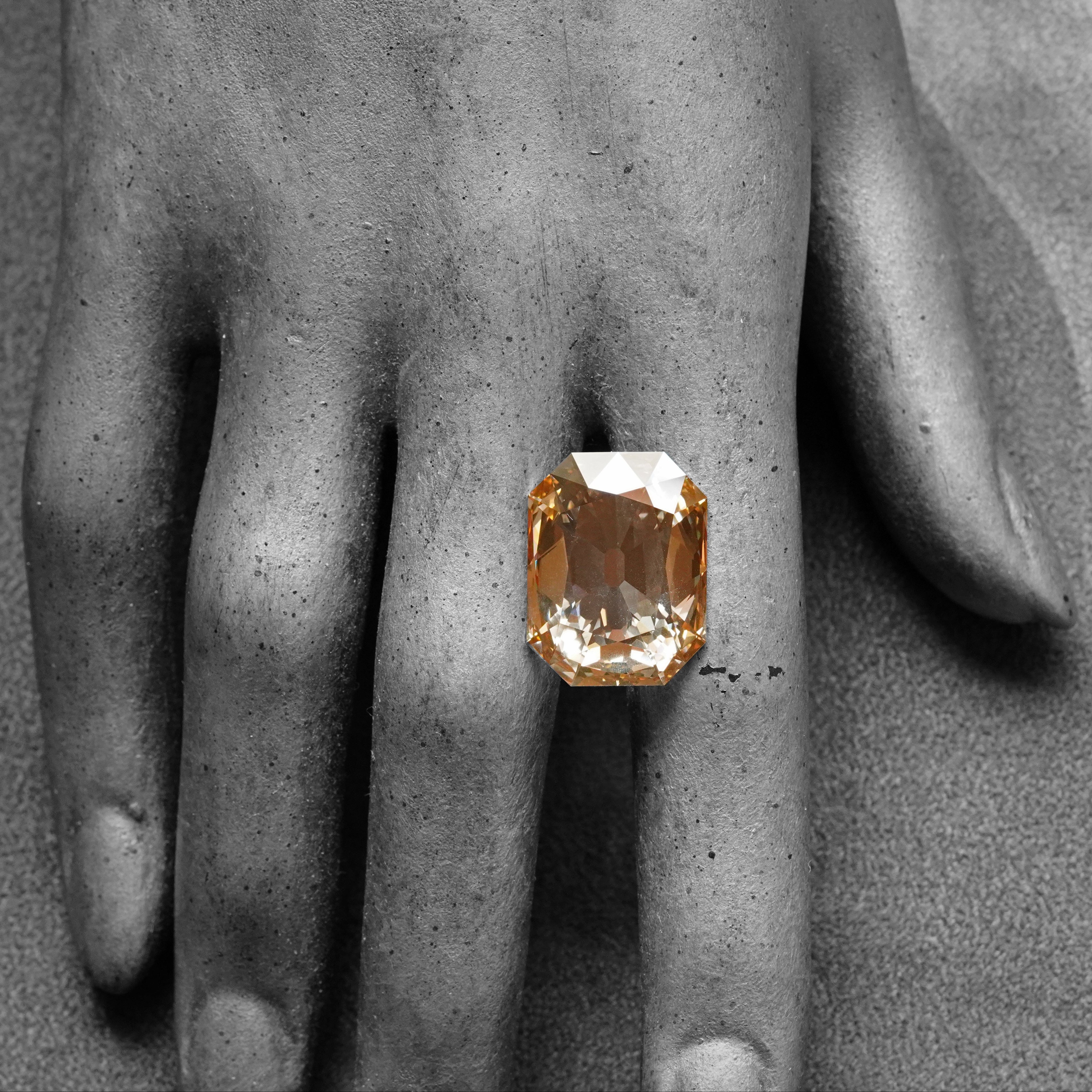 A 13.84-carat step-cut diamond with a fancy brown-yellow color, VVS2 clarity, and type IIa classification, accompanied by a GIA certificate.