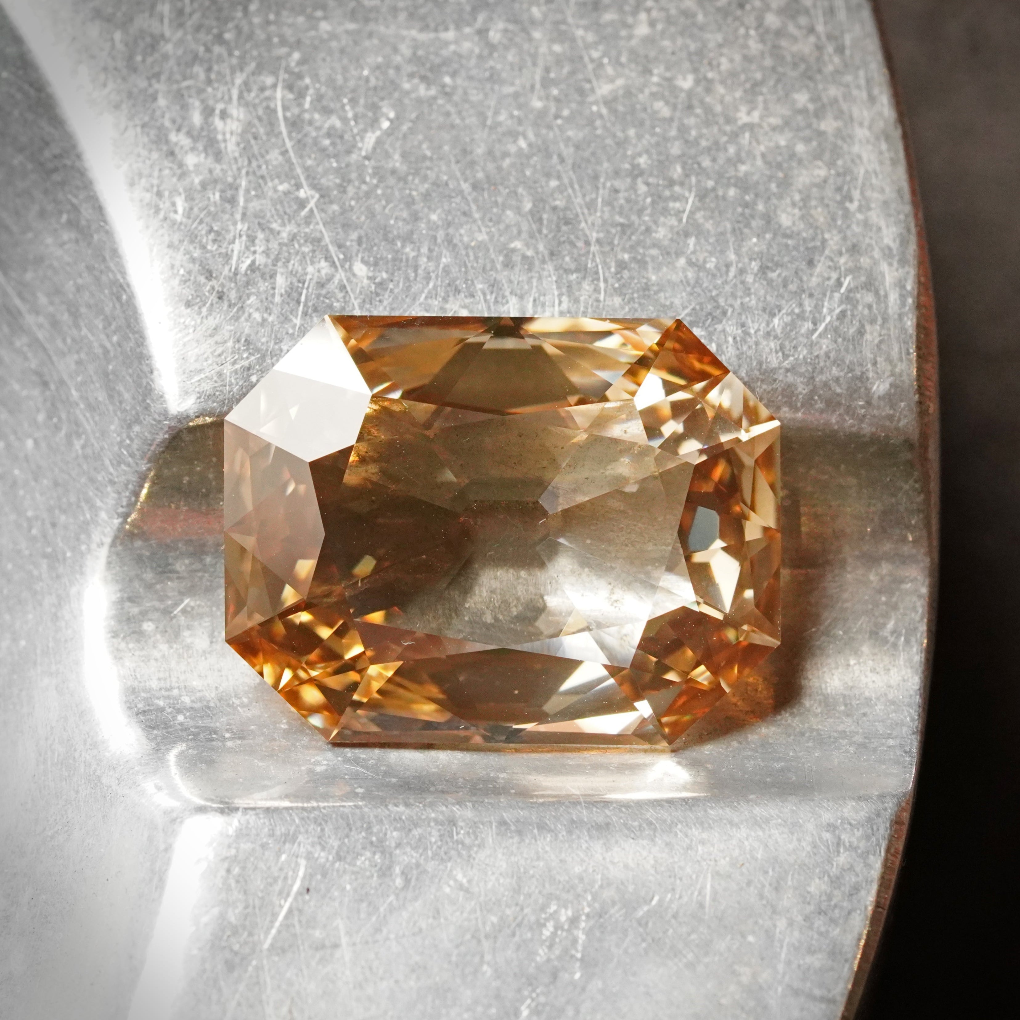 Detailed view highlighting the step-cut facets and exceptional clarity of a 13.84-carat fancy brown-yellow diamond, measuring 21.15 x 16.23 x 4.37 mm.