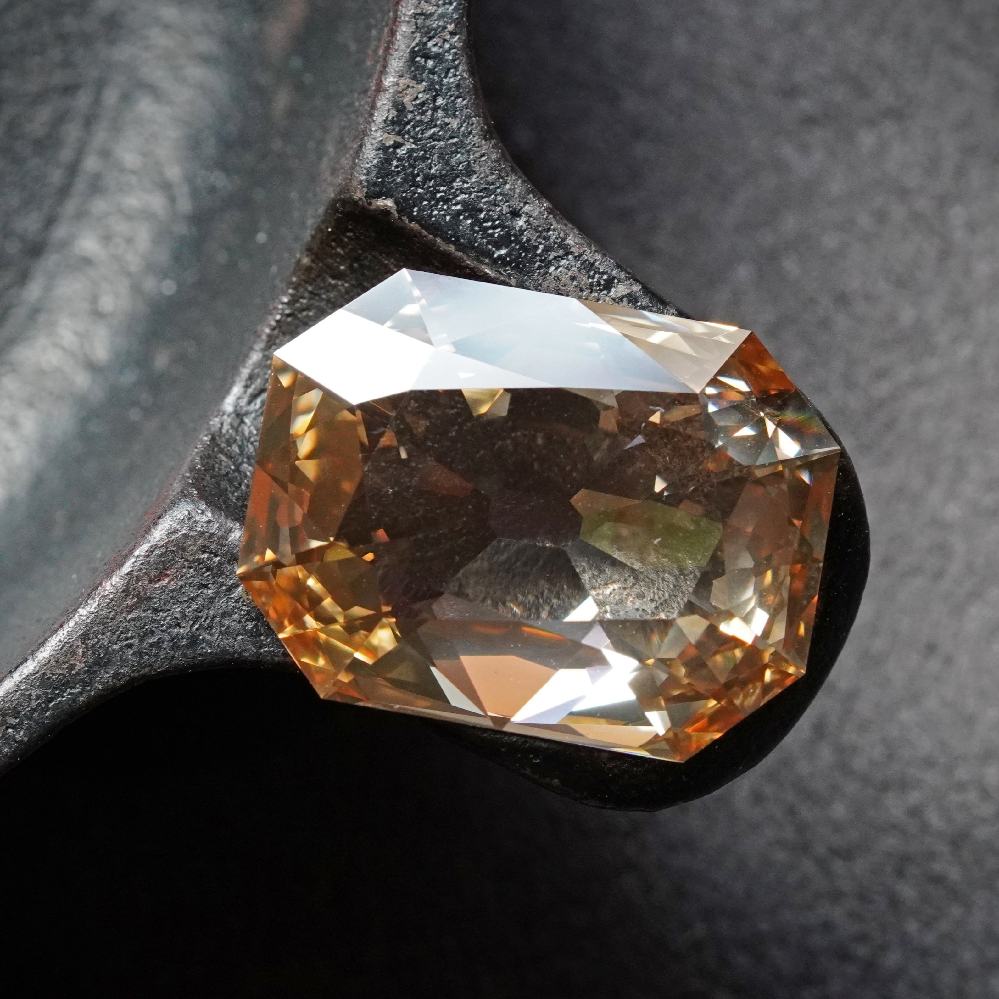 A 13.84-carat step-cut diamond with a fancy brown-yellow hue, VVS2 clarity, and type IIa classification, displayed against a black background.