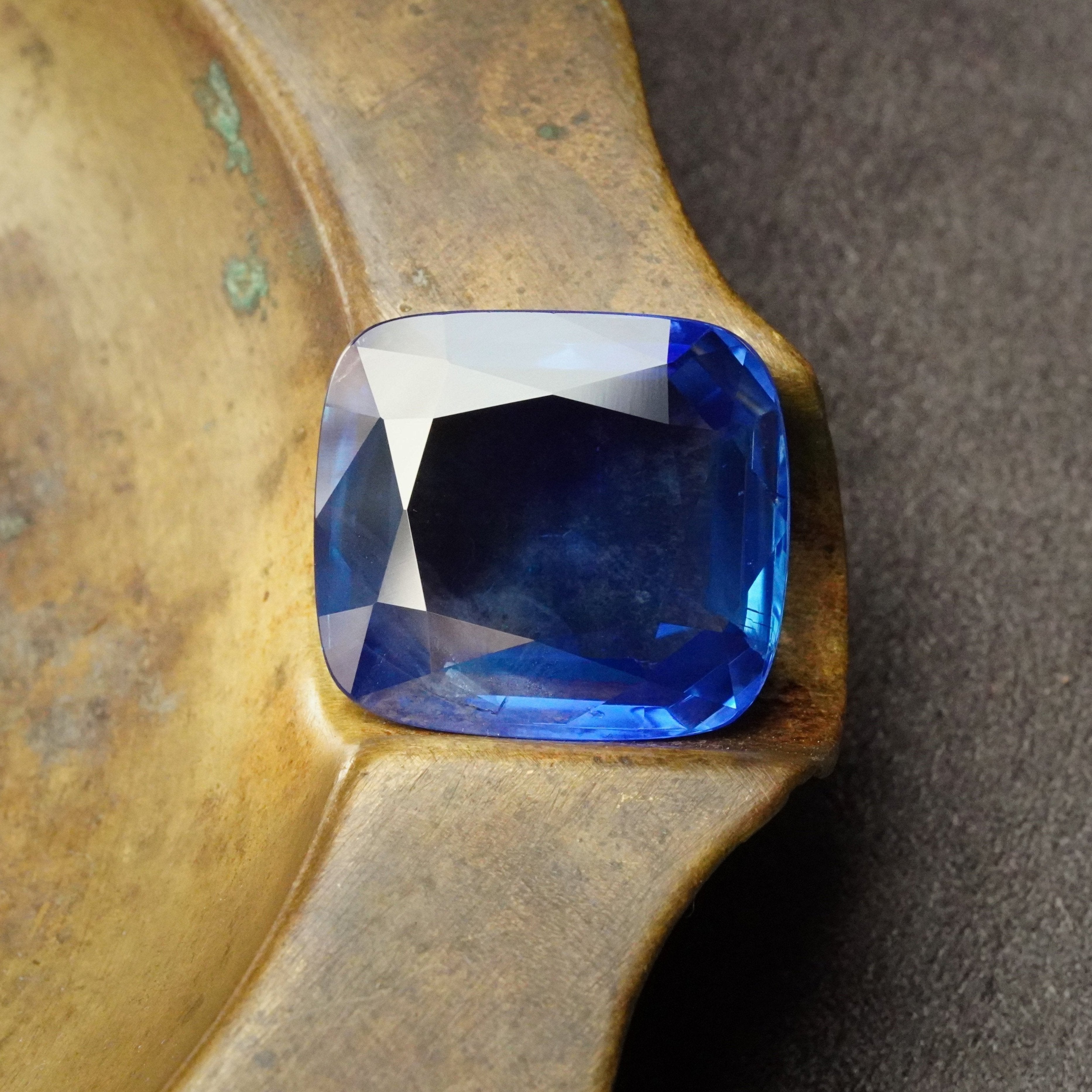 The stunning 19.95 ct flat cushion-cut Burma sapphire, available from Jogani. No-heat, antique gemstone with a deep blue hue, perfect for collectors and investors.