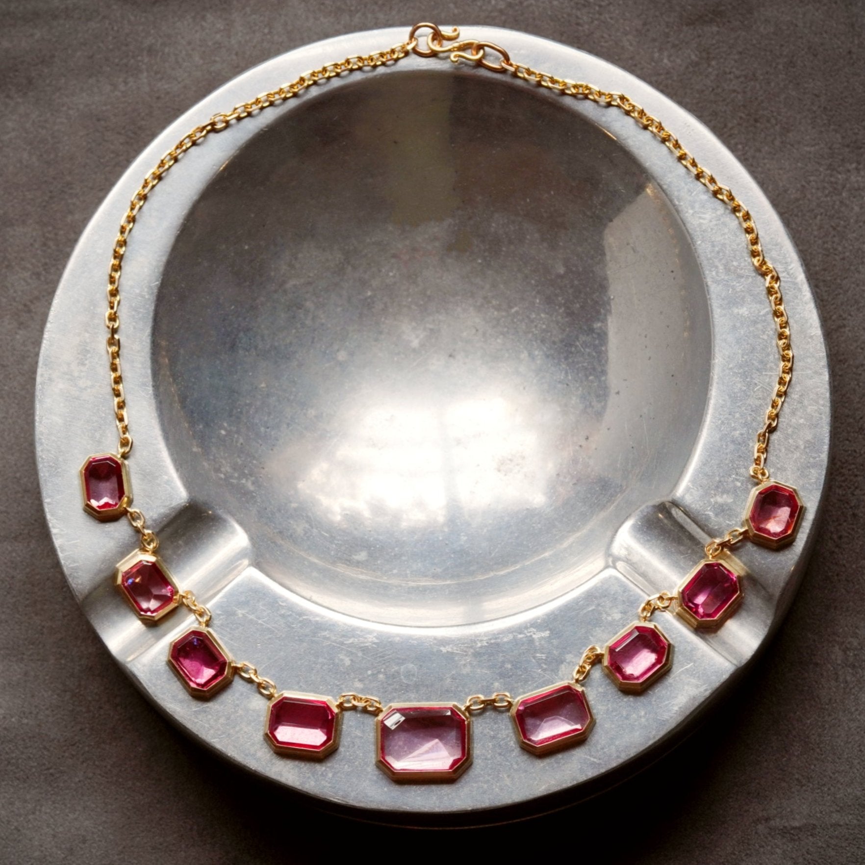 A one-of-a-kind 28.11 TCW Tajikistan pink spinel necklace, its luminous step-cut gems encased in platinum and 18K rose gold. A remarkable acquisition for discerning collectors.