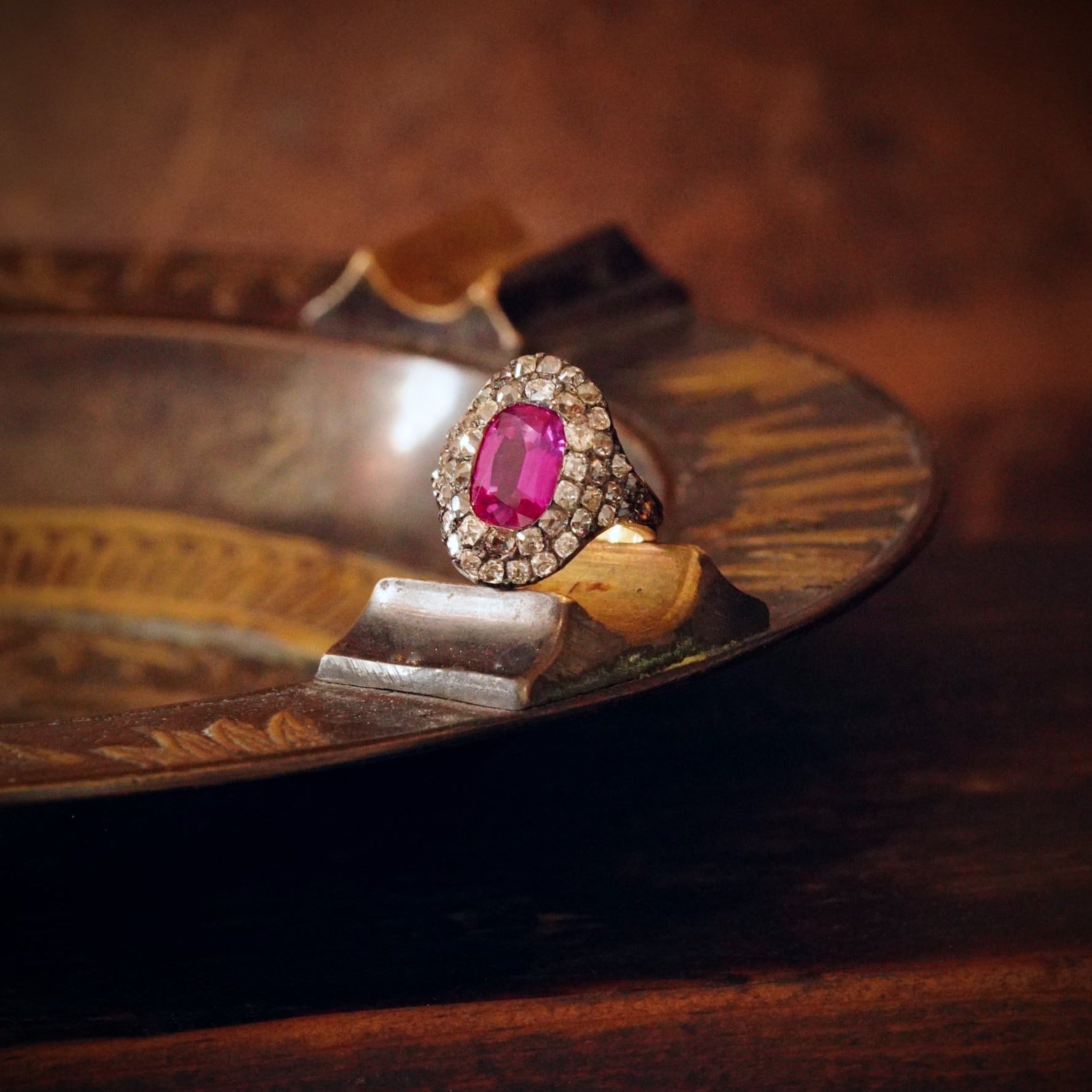 This rare 3.12 ct Georgian Burma Ruby Ring, with its unheated pink-red glow and shimmering diamond halo, is a masterpiece in 18K gold and silver. Discover it now with Jogani.