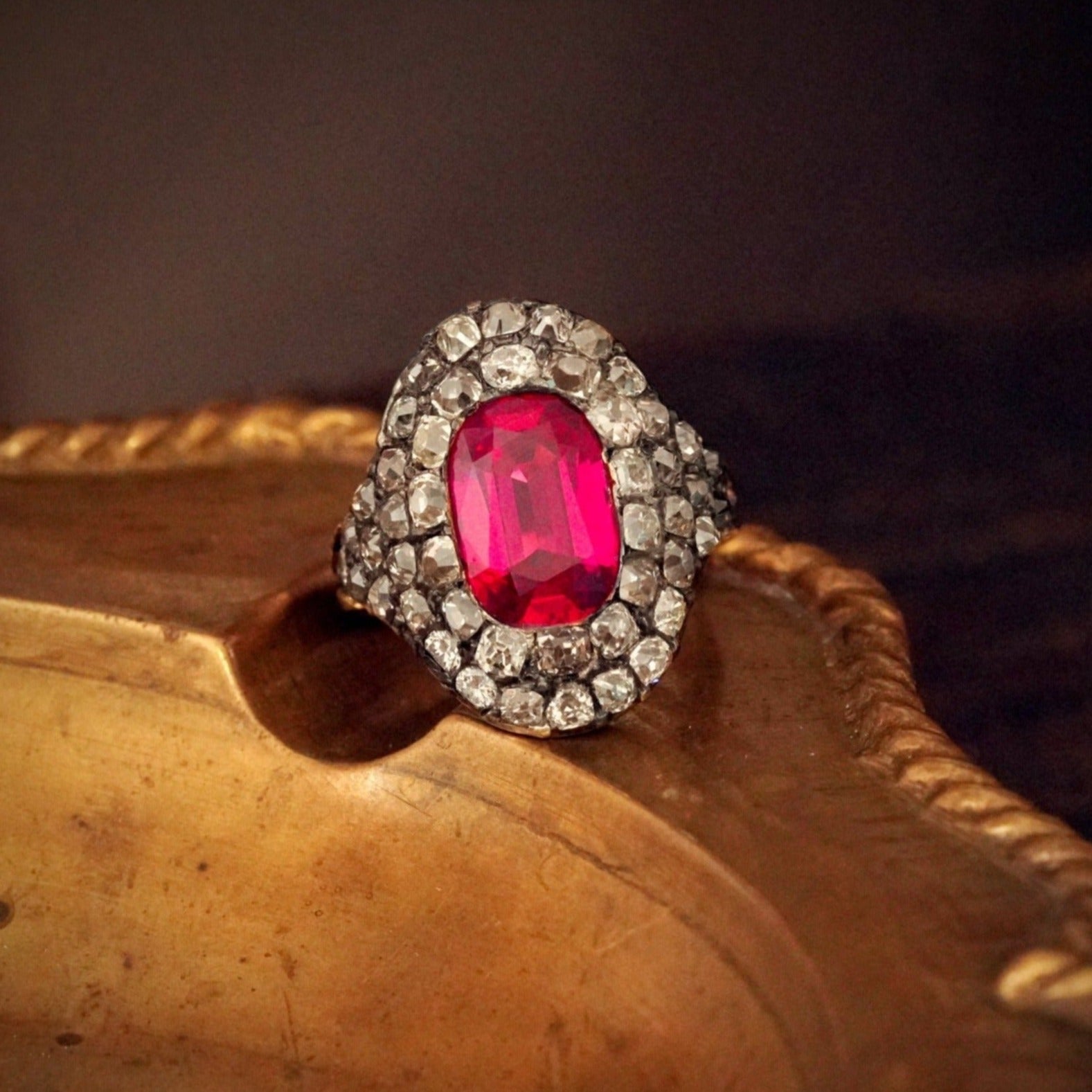 A magnificent 3.12 ct Georgian-era Burma Ruby and Diamond Ring, featuring a no-heat pink-red cushion cut ruby, encircled by antique table-cut diamonds. Available with Jogani.