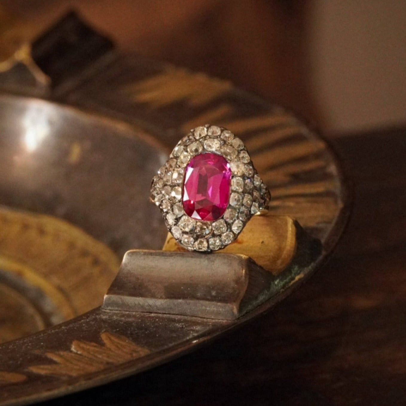 This 3.12 ct Cushion Cut Burma Ruby Ring, set in 18K yellow gold and silver, showcases an unheated, vivid pink-red ruby framed by historic table-cut diamonds. Offered by Jogani.