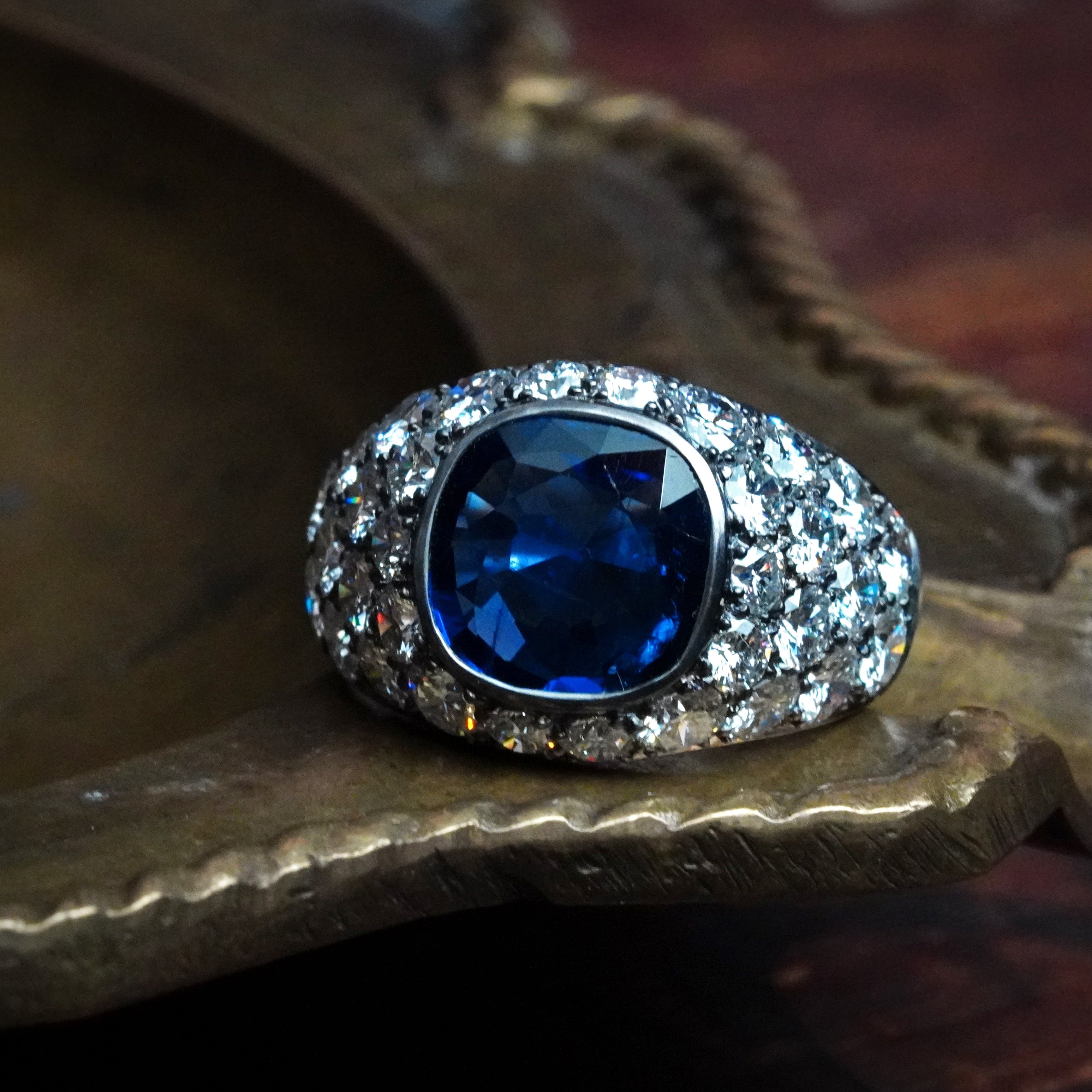 This striking cushion-cut 3.39 ct Burma sapphire, with vivid blue hues, is bezel-set in platinum by Jogani, creating a timeless statement of luxury.