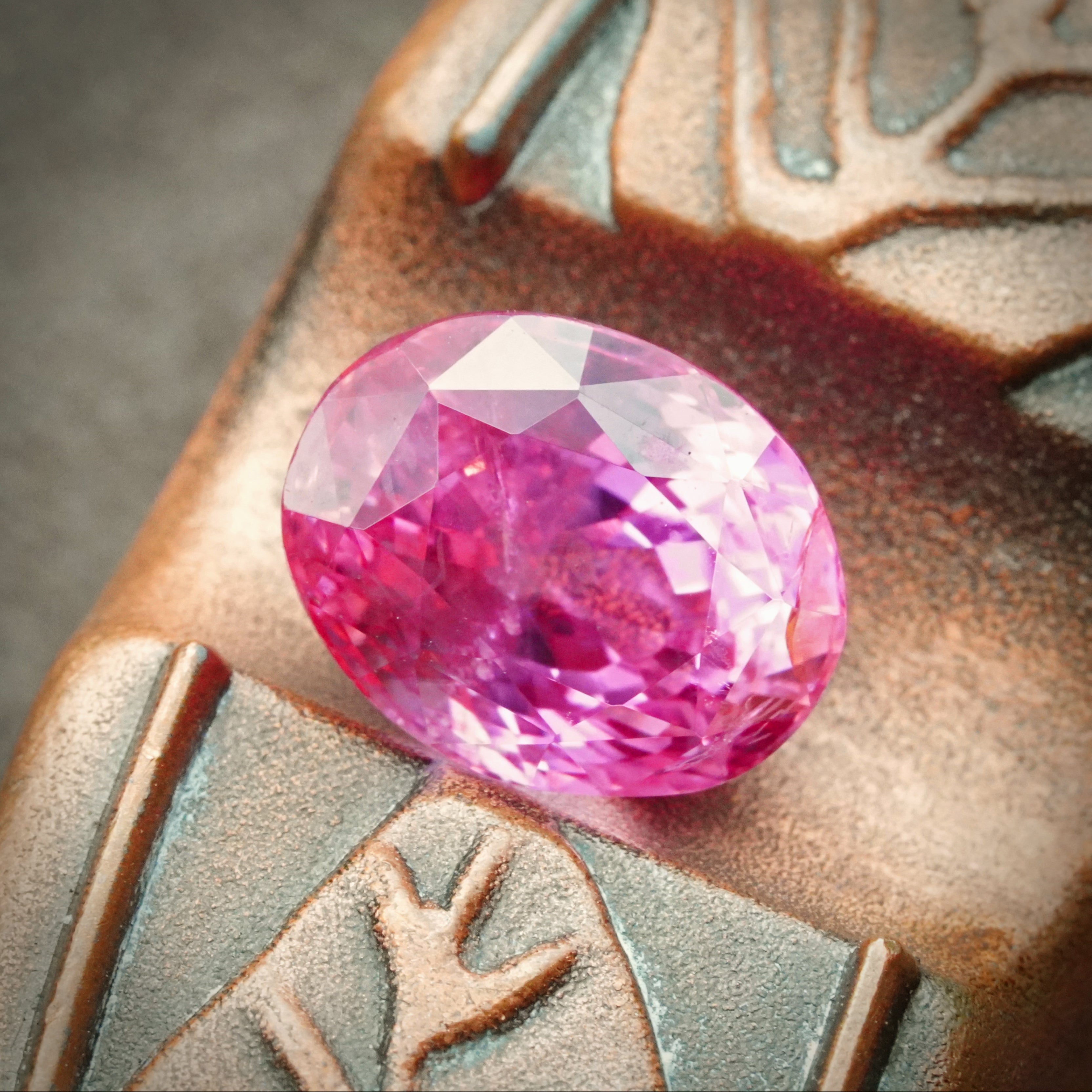 A 4.56-carat oval-shaped Ceylon Padparadscha sapphire, featuring a clean orangy-pink to pink-orange hue, measuring 9.89 x 7.86 x 6.69 mm, with no evidence of heat treatment, accompanied by an AGL certificate number 1144014, presented by Jogani.