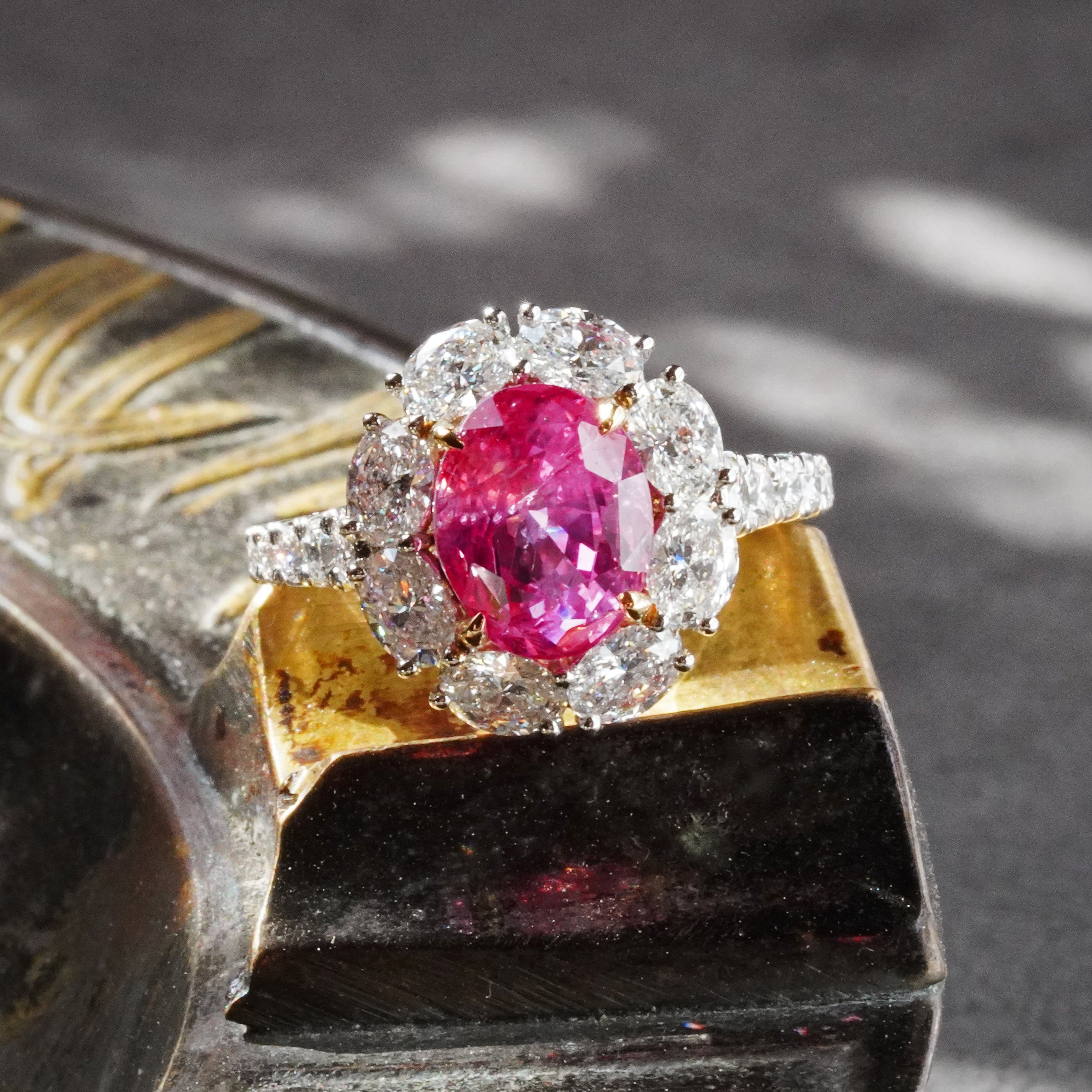 A 4.56-carat oval-shaped Ceylon Padparadscha sapphire, featuring a clean orangy-pink to pink-orange hue, measuring 9.89 x 7.86 x 6.69 mm, with no evidence of heat treatment, previously set in a diamond ring, presented by Jogani.