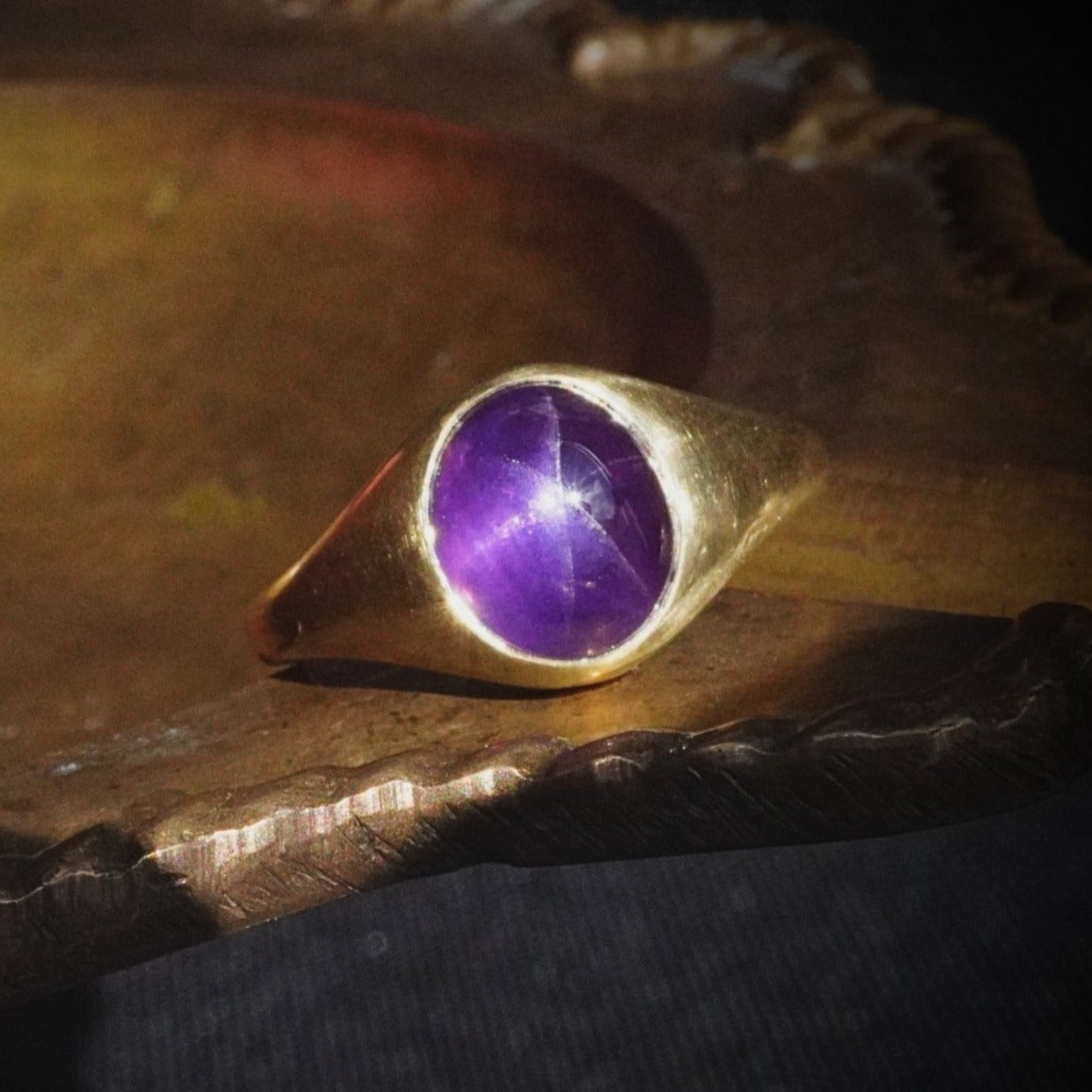 A mesmerizing 4.82 ct Star Ceylon Sapphire Ring, set in rich 18K yellow gold. This bezel-set masterpiece, made by Jogani, showcases a luminous purple star sapphire.