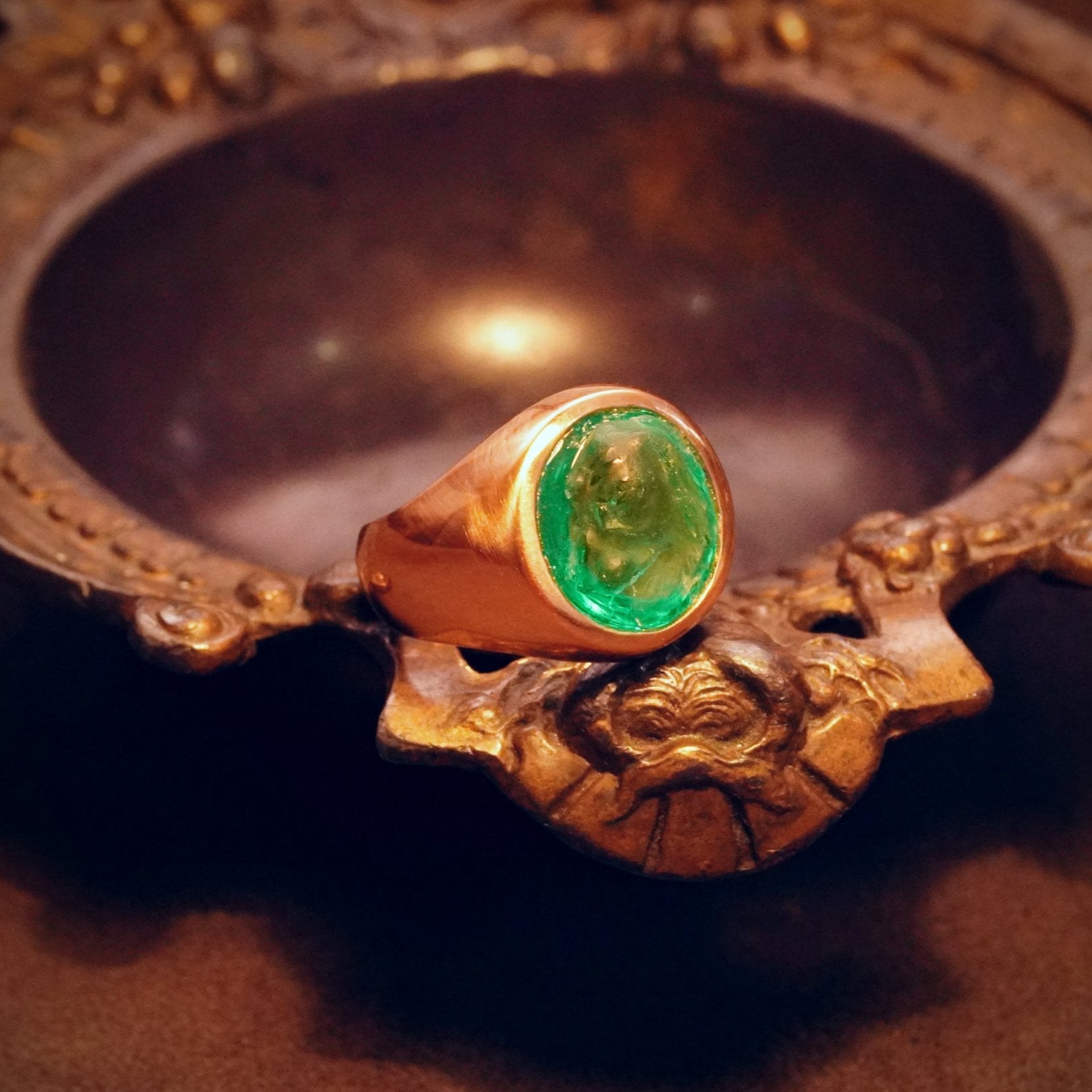 A rare 6.45 ct Colombian emerald, featuring an elegant canine carving, set in a vintage-inspired 18K gold ring by Jogani. Perfect for connoisseurs and investors.