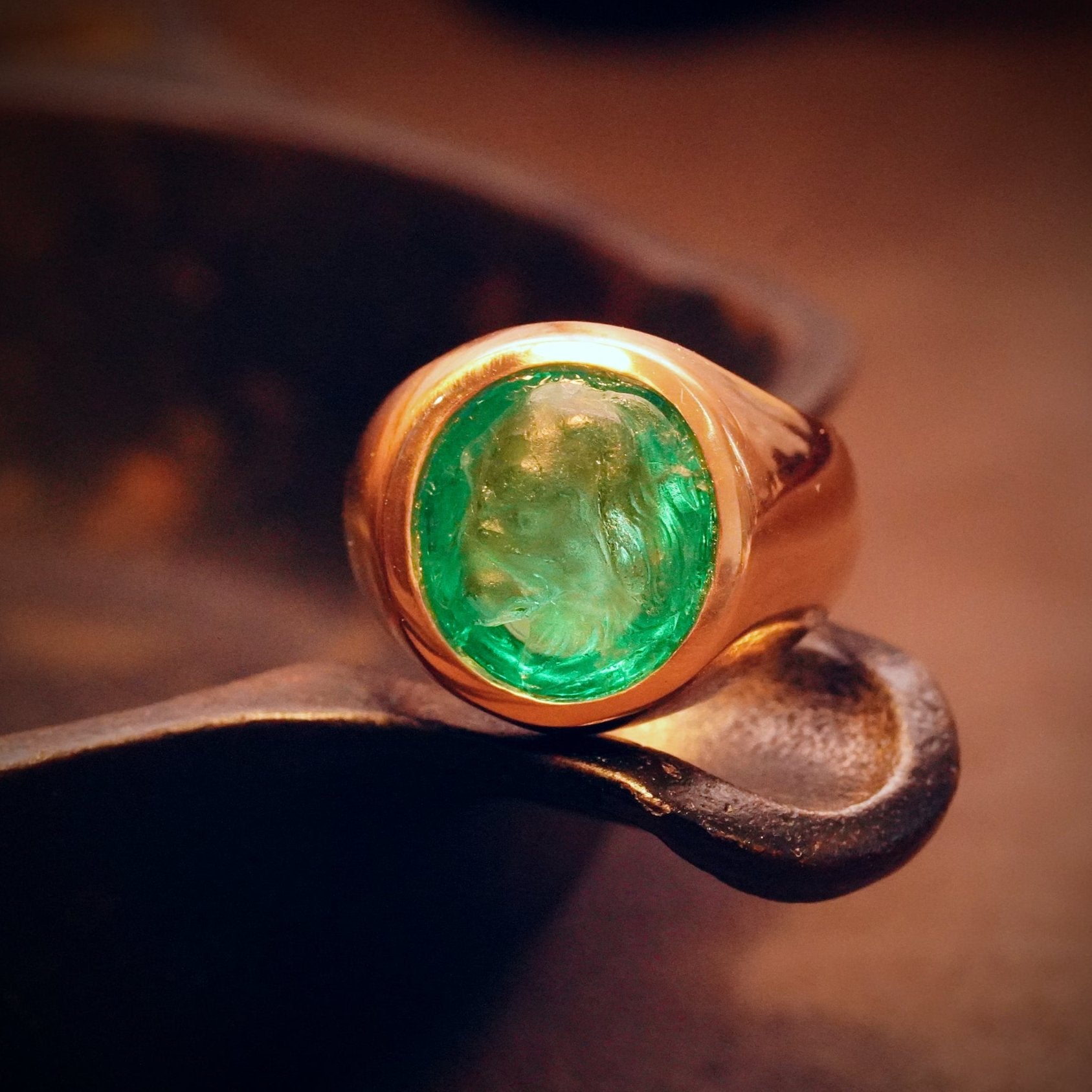 A captivating 6.45 ct emerald, intricately carved dog in a Victorian style, glowing with Colombian green hues. Set in 18K gold, available now through Jogani.