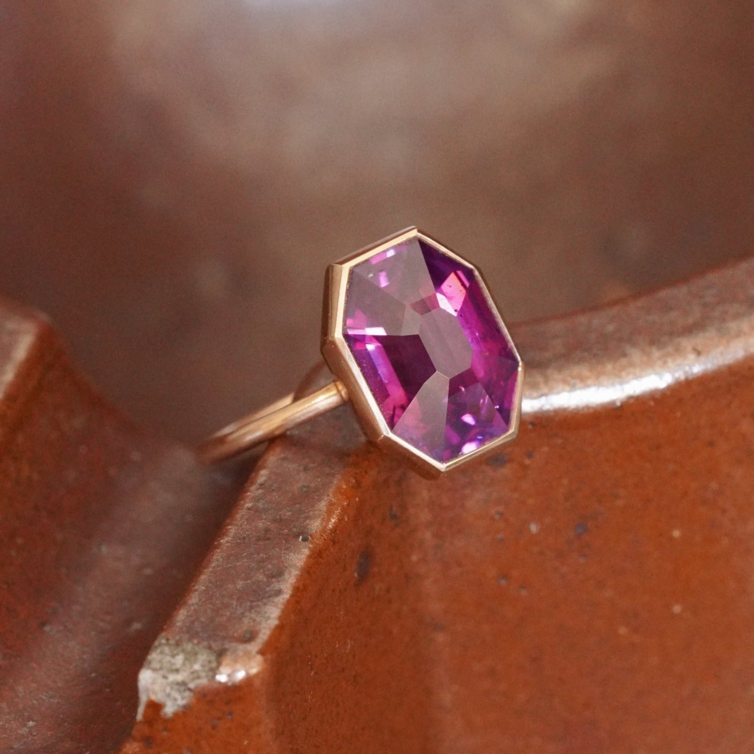 This no-heat Ceylon sapphire ring from Jogani, featuring a deep purplish-reddish pink step-cut sapphire, captivates jewelry aficionados and collectors alike.