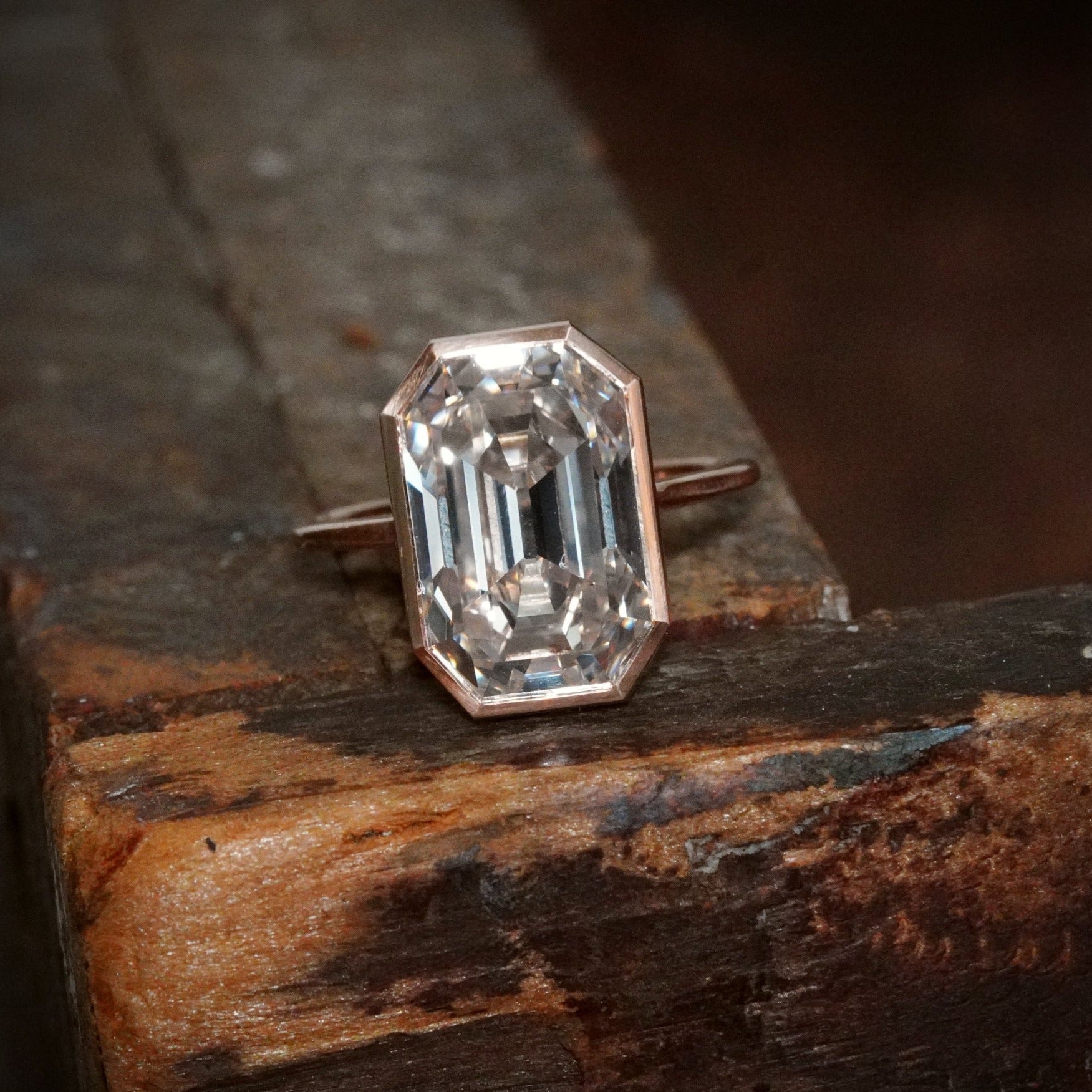 This 8.06 ct Step Cut Diamond Ring, made by Jogani, showcases understated elegance with its L-color diamond, bezel-set in a striking rose gold and platinum design.