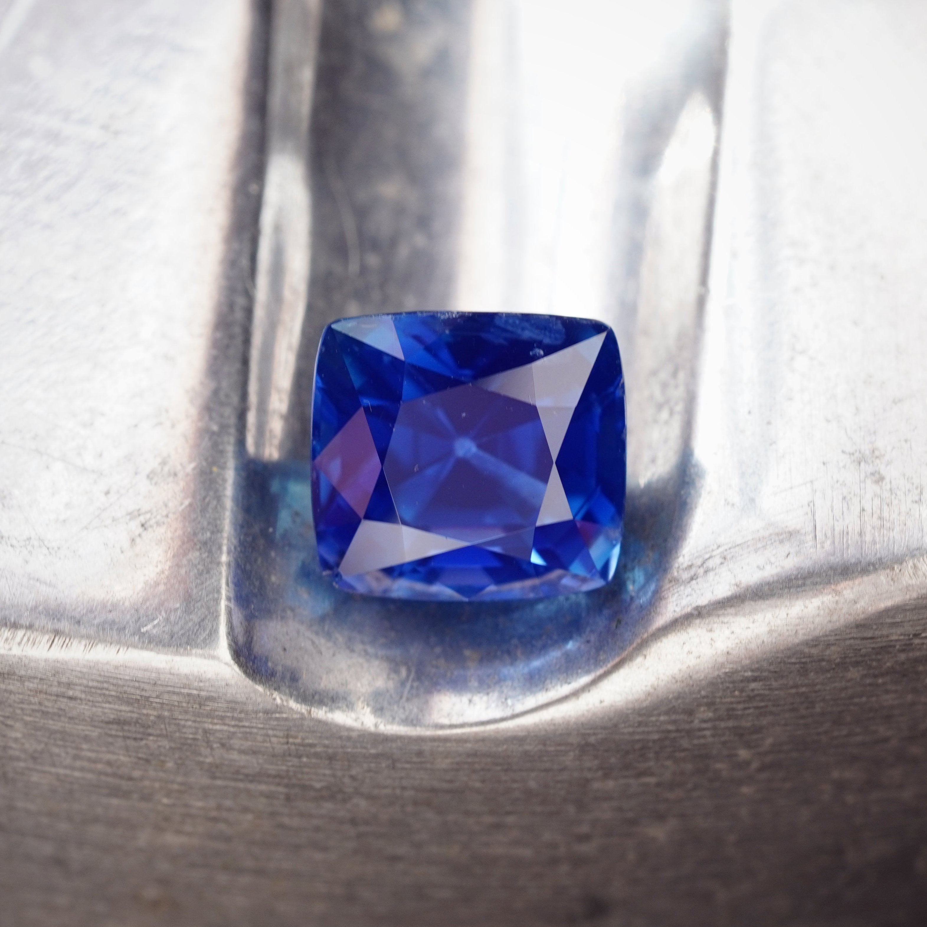 Jogani's stunning 8.22 ct cushion-cut Kashmir sapphire, boasting an intense blue hue and clean clarity. A rare, investment-worthy gem with elite certifications.