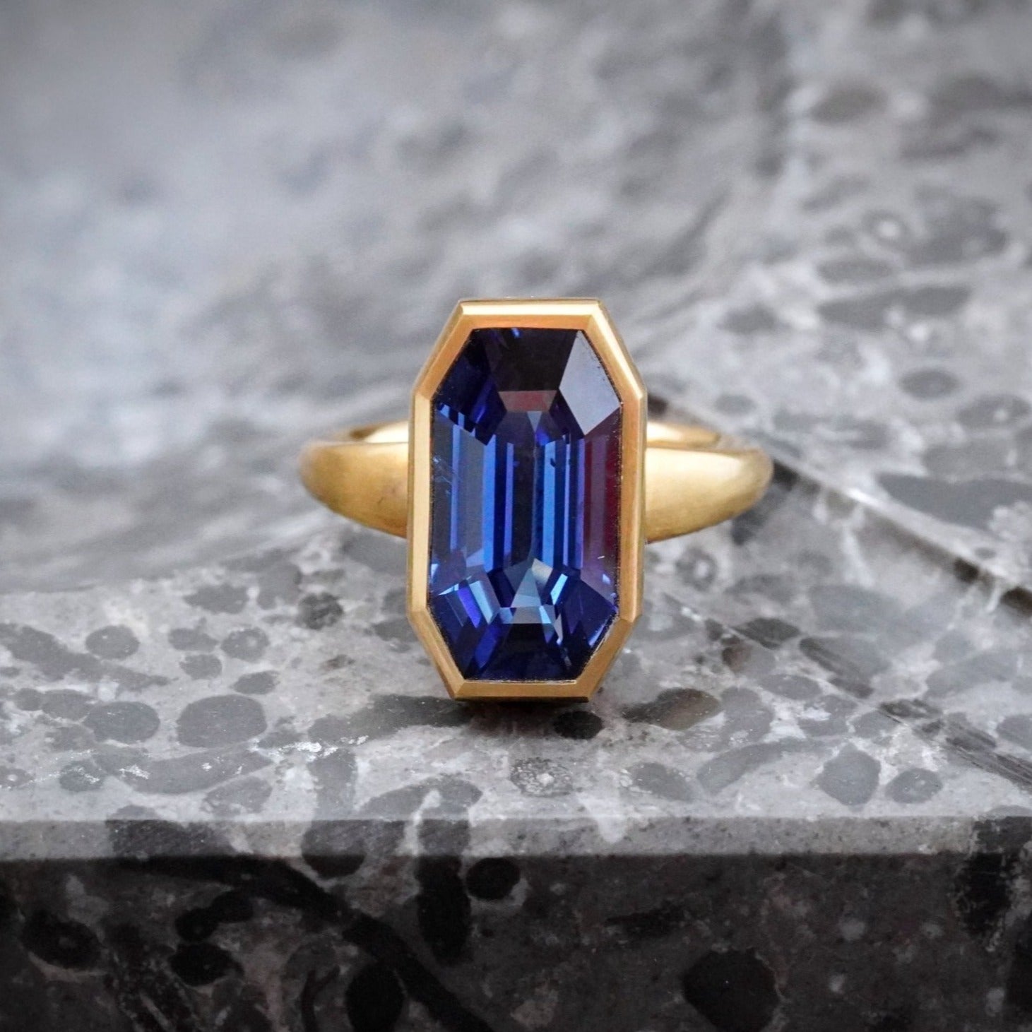 Exquisite 9.10 ct Burma sapphire ring, step-cut and bezel-set in 18K yellow gold, crafted with Jogani’s signature dedication to timeless design and investment-worthy gemstones.