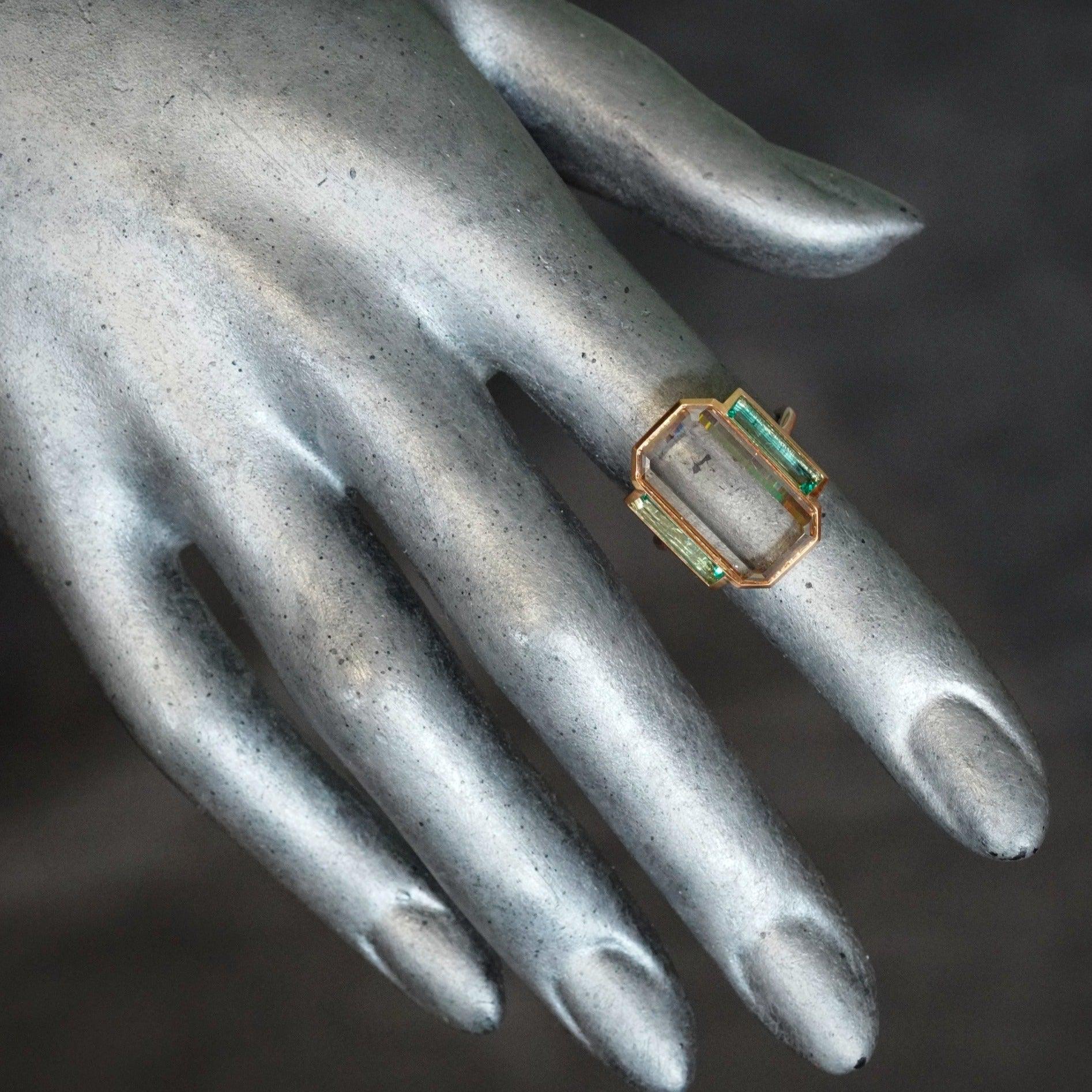 Handcrafted jewelry featuring step cut emeralds and a large diamond