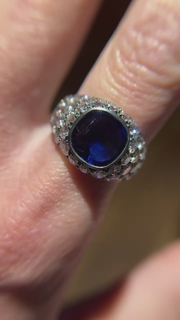 Jogani’s platinum bezel-set ring highlights an exceptional 3.39 ct cushion-cut Burma sapphire, glowing with rich blue color and timeless elegance.