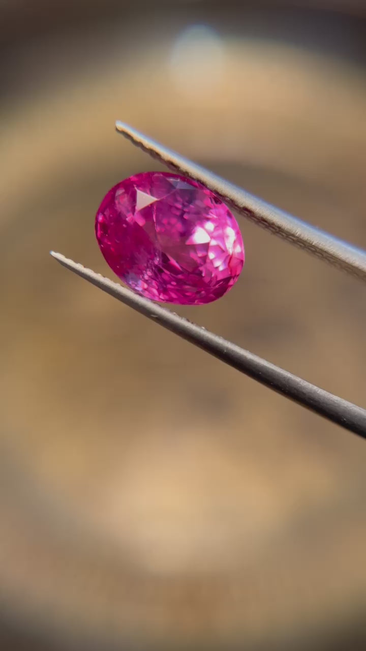 A 4.56-carat oval-shaped Ceylon Padparadscha sapphire, featuring a clean orangy-pink to pink-orange hue, measuring 9.89 x 7.86 x 6.69 mm, with no evidence of heat treatment, accompanied by an AGL certificate number 1144014, presented by Jogani.