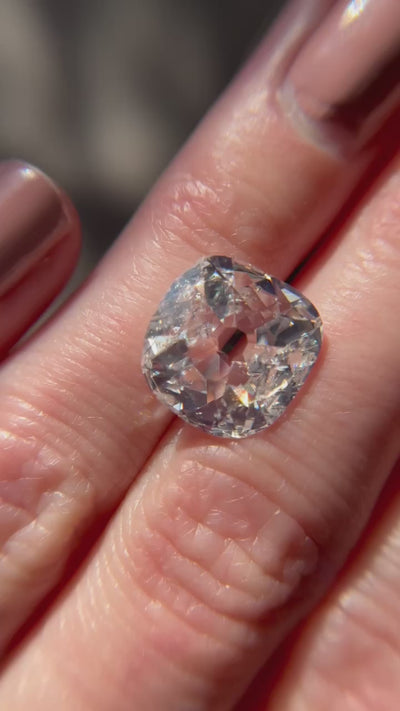 A 5.02-carat cushion-cut diamond with G color and I2 clarity, measuring 12.96 x 12.63 x 4.28 mm, accompanied by GIA certificate number 5231488524, presented by Jogani, displayed on a hand under sunlight.