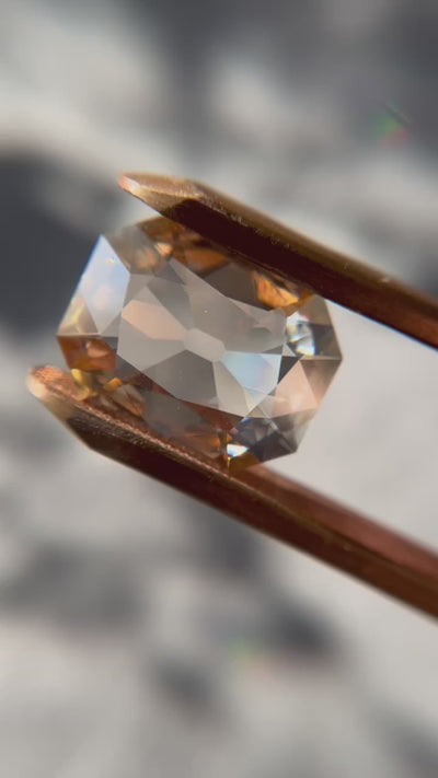 A 13.84-carat step-cut diamond with a fancy brown-yellow color, VVS2 clarity, and type IIa classification, accompanied by a GIA certificate.