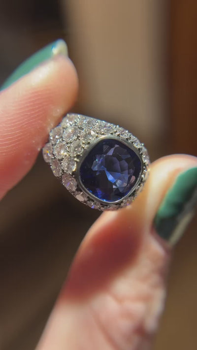 An extraordinary 3.39 ct cushion-cut Burma sapphire, clean and untreated, set in platinum by Jogani with a luminous diamond halo—a collector’s delight.