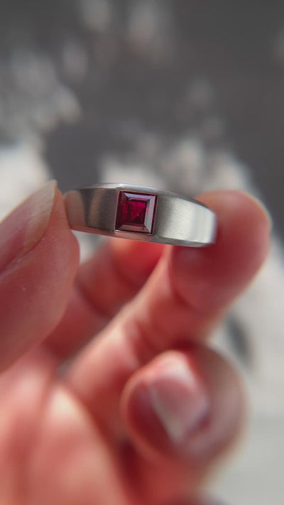 Close-up of a 1.15-carat step-cut Burmese ruby ring, highlighting the clean red gemstone and platinum flush setting, presented by Jogani.